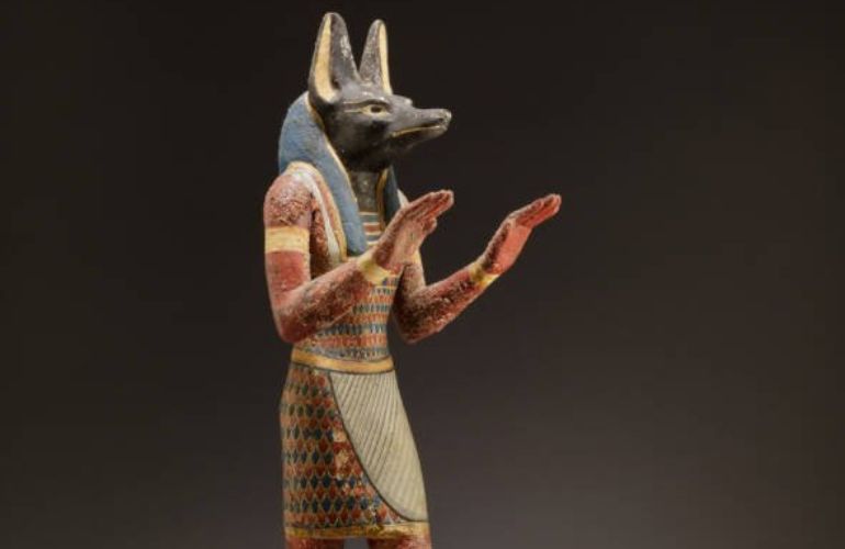 A statue portraying the Egyptian god Anubis with a jackal’s head and man’s body.